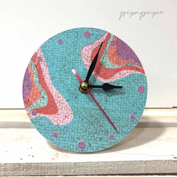 reloj sobre mesa de papel reciclado hecho a mano