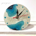 reloj sobre mesa de papel reciclado hecho a mano