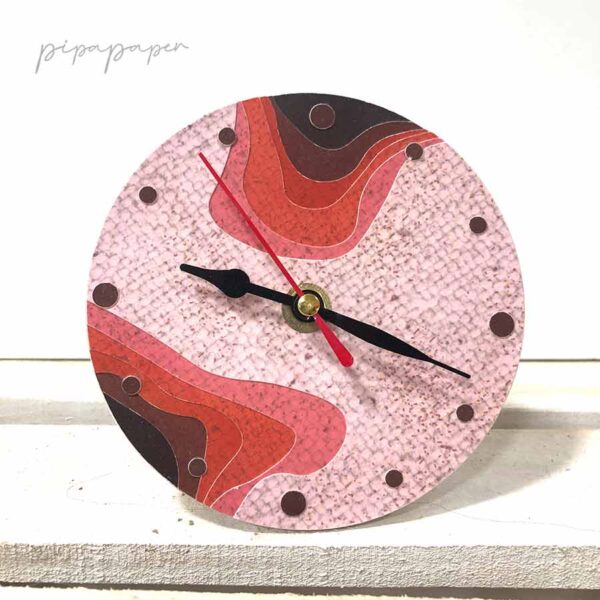 reloj sobre mesa de papel reciclado hecho a mano