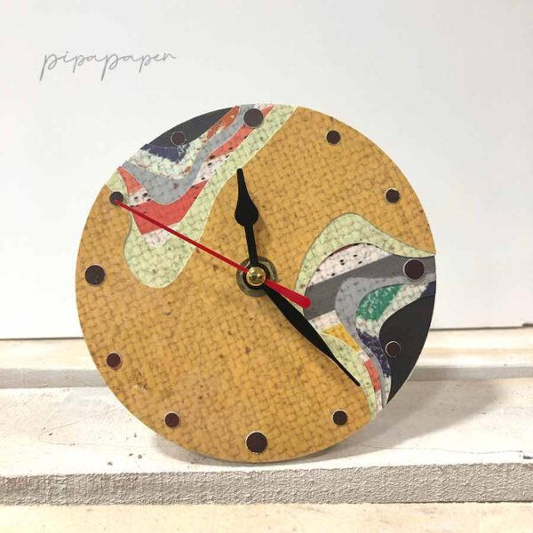 reloj sobre mesa de papel reciclado hecho a mano